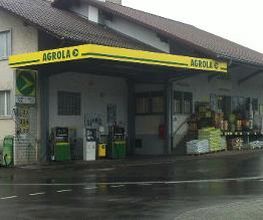 AGROLA Tankstelle in Neuenegg überdacht; regnerische Aufnahme mit nasser Strasse; zwei Tanksäulen mit Zahlterminal