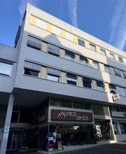 Frontansicht auf Bürogebäude, im unteren Eingangsbereich Logo und Eingangsbereich eines Fahrradladens.