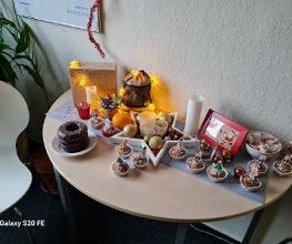 Ein Tisch mit Weihnachtsschmuck und Muffins.