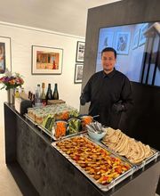 dean&david Catering | Stuttgart - Catering Station mit Gemüsesticks, Dips, Fladenbrot und Spießen, betreut von Servicepersonal für frisches Fingerfood bei Events.