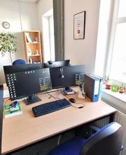 PC-Arbeitsplatz mit zwei Monitoren, Tastatur, Maus und Headset.