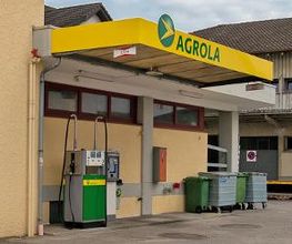 AGROLA Tankstelle in Boswil; überdachte Tankstelle mit einer Tanksäule; an Hausmauer gelegen; Abfalleimer grün und metall daneben