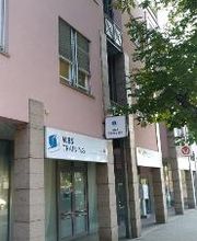 Außenansicht Gebäude Dresden SAußenansicht vom Gebäude mit Eingangsbereich. Rote Fassade und WBS TRAINING Schild. 