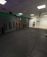 TA WingTsun Seelze - Weitläufiger Übungsraum mit Mattenboden, Trainingsgeräten, Wandpolstern und klassischer Holztrainingspuppe für effektives Selbstverteidigungstraining und Kampfkunst.