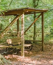 Eine überdachte Bank im FriedWald Ostheide lädt zum Verweilen ein.