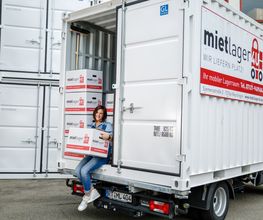 Frau mit Karton im Lagercontainerauf LKW.jpg
