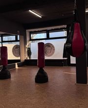 TA WingTsun Langenhagen - Atmosphärischer Trainingsbereich mit Spiegelwand, Standboxsäcken, Tageslicht und großzügiger Fläche für Kampfkunst, Fitness und Selbstverteidigungstraining.