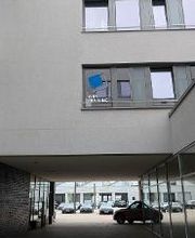 Außenansicht des Gebäudes und Parkplatz. Blaues WBS TRAINING Logo auf einem Fenster.