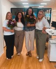 4 Damen die freundlich und herzlich in die Kamera schauen.