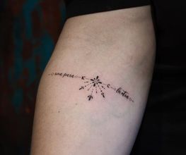 Schriftzug Tattoo mit Ornamenten und Dotwork am Unterarm.