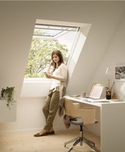 Ein helles Arbeitszimmer mit Dachfenster, das Tageslicht und frische Luft bietet. Die moderne Einrichtung fördert eine produktive Atmosphäre.