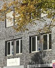 Nahaufnahme von der Etage im Gebäude in der sich die Schulungsräume von WBS TRAINING befinden mit Schildern an den Fenstern.