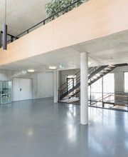 Foto und Filmproduktion Laila Tkotz Weitwinkelaufnahme von lichtdurchflutetem Eingangsbereich mit Glas und Beton