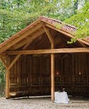 Ein überdachter Holzpavillon im FriedWald Burg Plesse bietet Schutz bei unbeständigem Wetter.