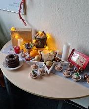 Ein Tisch mit Weihnachtsschmuck und Muffins.