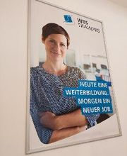 Plakat WBS TRAINING mit Frau und Text "Heute eine Weiterbildung. Morgen ein neuer Job."