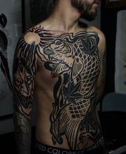 Blackwork-Frontpiece eines Koi-Fisches mit Blättern über Brust und Schulter.
