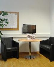 Aufenthaltsbereich mit zwei Sesseln und Tisch.