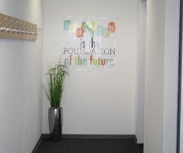 WBS - Eingangsbereich mit Pflanze und einem Plakat, auf dem "Education is the foundation of the future" steht.