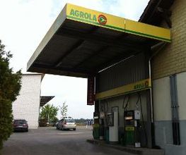 AGROLA Tankstelle in Uettligen, Bern; überdacht an Hausfassade; zwei Tanksäulen und ein Zahlterminal