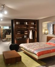 Exklusiver begehbarer Kleiderschrank aus edlem Dunkelholz bei Möbel Schmitz in Trier. Wir fertigen maßgeschneiderte Schrankraumlösungen, die von unseren eigenen Schreinern passgenau eingebaut werden.