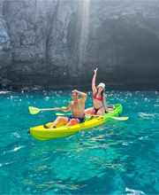 pareja de novios enncima de un kayak amarillo en mar cristalino