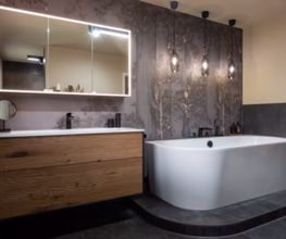 Wellness-Oase mit Badewanne: Großzügiges Bad mit freistehender Wanne, dunkler Akzentwand, hölzernem Waschtisch und moderner Beleuchtung. Die perfekte Komposition aus Fliese und Tapete im Badezimmer.