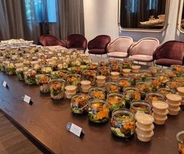 dean&david Catering | Stuttgart - Reihenweise frische Salate im Glas mit separatem Dressing, Wraps und Bowls auf einem langen Buffet für eine professionelle Veranstaltung.