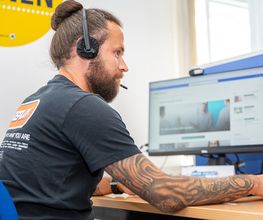 Teilnehmer mit Headset auf dem Kopf im Unterricht