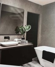 Martin Otto Thie Raumgestaltung Inh. Aline Sander e.K. elegantes Badezimmerdesign in warmen Naturtönen mit freistehender Badewanne. Kombination aus Minimalismus und wohnlicher Atmosphäre in der Raumgestaltung.