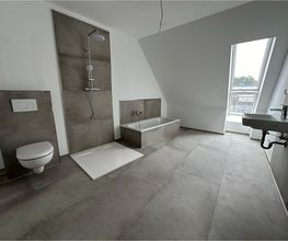 Fertiges Bad im Dachgeschoss mit großformatigen Fliesen, Dusche und Badewanne. Ein Projekt von AS-Bau.