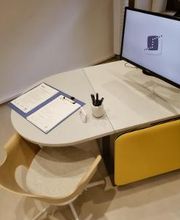 Blick auf einen im Beratungsraum. Auf dem Tisch steht ein Computer-Monitor mit WBS TRAINING Logo als Bildschrimschoner  sowie ein Klemmbrett mit Dokumenten.