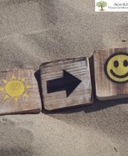 Smiley im Sand mit Sonne