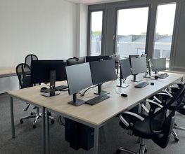 WeiterbilEin Schulungsraum mit mehreren Arbeitsbereichen. Jeder Arbeitsplatz besteht aus 2 PC-Bildschirmen, Tastatur und Maus sowie Headset.dung bei der WBS - moderne Arbeitsumgebung