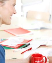 Nachhilfelehrerin sitzt am Tisch mit Lernmaterialien.