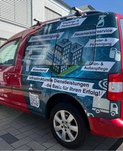 Kompakter Transporter mit detailreicher Fahrzeugvollfolierung in Rot- und Blautönen. Großformatige Bildmotive, Firmenlogo und Leistungsübersicht verwandeln das Fahrzeug in eine aufmerksamkeitsstarke mobile Werbefläche.