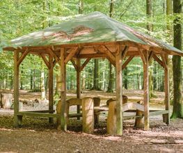 Eine überdachte Sitzgruppe im FriedWald Kisdorf lädt zum Verweilen ein.