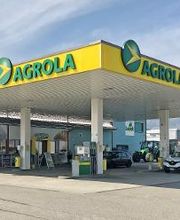 AGROLA Tankstelle in Grenchen; überdacht mit TopShop. Grosses Dach mit zwei AGROLA Schriftzügen; im Hintergrund Landi Laden