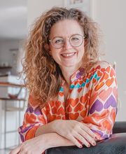 Webstudio Dresden Fröhliches Portrait einer Frau mit Locken und Brille, natürliche Ausstrahlung und positive Stimmung.