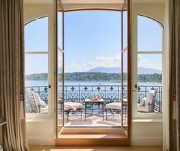 Luxurious suite balcony at The Woodward Geneva overlooking Lake Geneva and the distant Alps.
