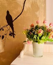 Liebevoll gestaltetes Studio Detail mit Blumen, warmer Wandgestaltung und ruhiger Atmosphäre.