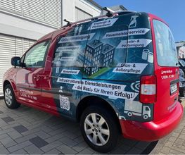 Kompakter Transporter mit detailreicher Fahrzeugvollfolierung in Rot- und Blautönen. Großformatige Bildmotive, Firmenlogo und Leistungsübersicht verwandeln das Fahrzeug in eine aufmerksamkeitsstarke mobile Werbefläche.