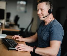 Ein Teilnehmer sitzt an seinem Arbeitsplatz und trägt sein Headset.