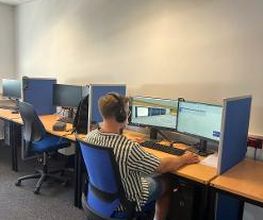 Ein Teilnehmer sitzt an seinem Arbeitsbereich, trägt sein Headset und lernt.