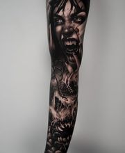 fullsleeve auf dem Arm, Black und Gray Horror Tattoo. Das Gesicht einer Vampirfrau ist das Hauptmotiv.
