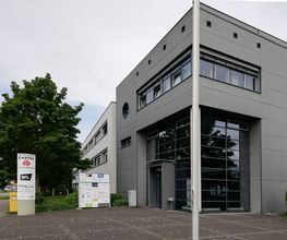 Außenansicht des Gebäudes. Graue Fassade mit Fenstern.