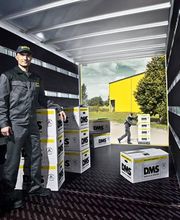 Mitarbeiter zwischen gestapelten DMS-Umzugskartons im Lkw