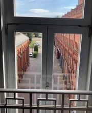 Fenster mit Aussicht aus der zweiten Etage auf Backsteingebäude.