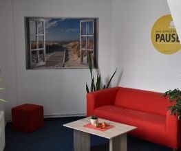 Pausenbereich mit einem Tisch und rotem Sofa.