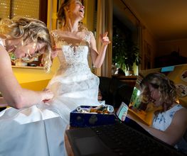 Hochzeitsfotograf Tom Maiwald - Fröhlicher Moment beim Getting Ready: Die Braut wird beim Ankleiden ihres Hochzeitskleides unterstützt. Natürliche Hochzeitsreportage mit echten Emotionen vor der Trauung.